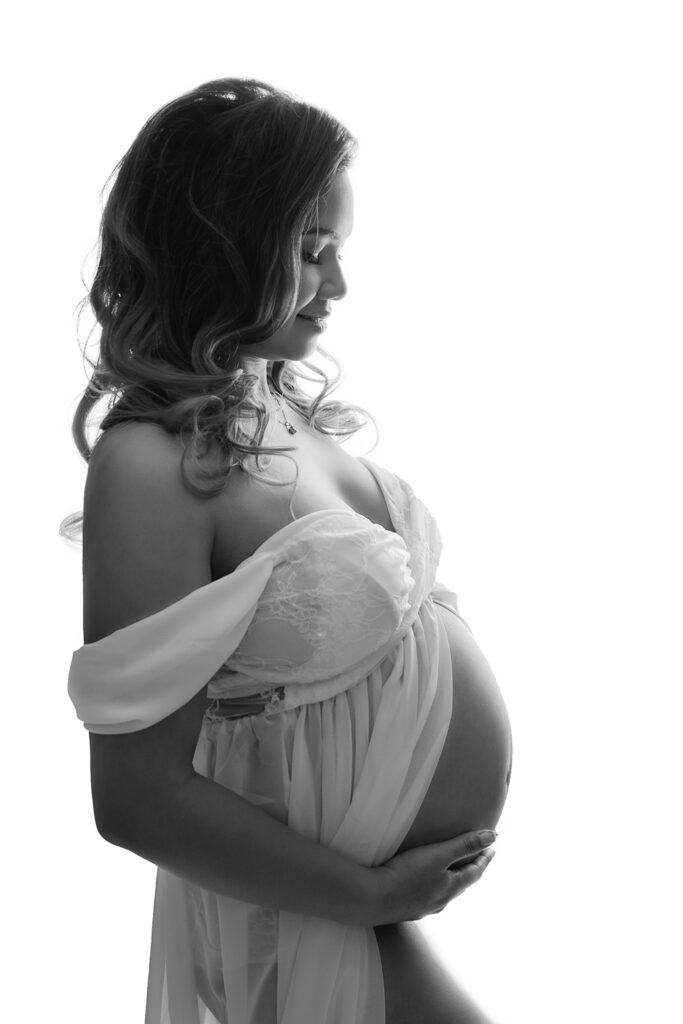 Pregnant woman at in studio Mississauga maternity session holding her belly, by Tamara Danielle Photography