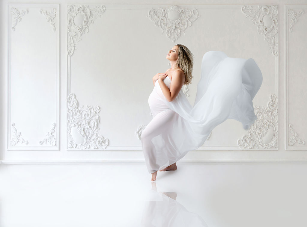 pregnant woman in white maternity gown with train flying