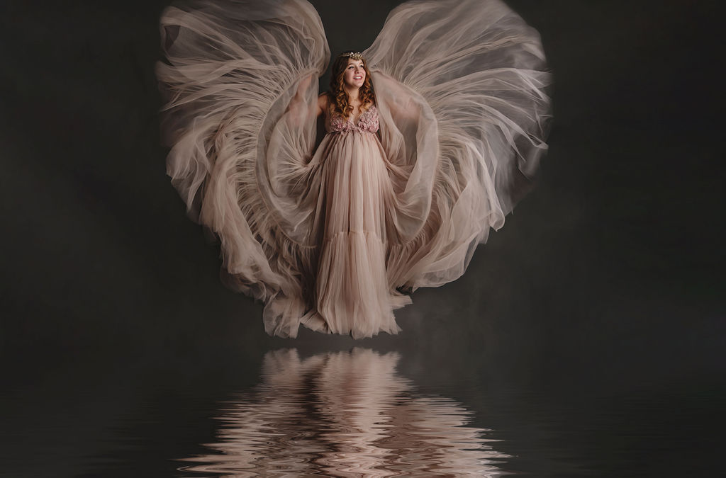 pregnant woman in pink. maternity gown with angel wings