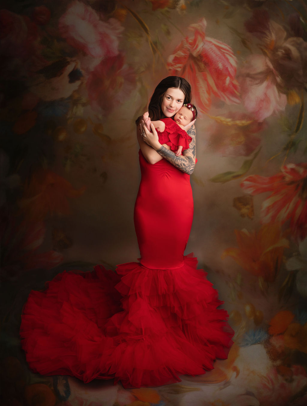 mom to be in red gown holding her newborn baby Midwives of Oakville